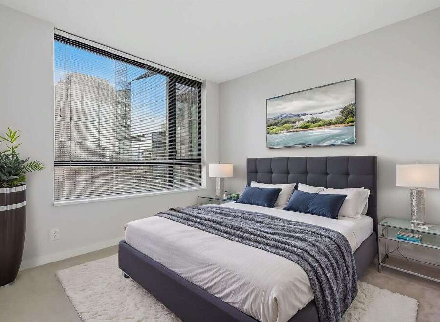 Experience luxury living in this stunning bedroom! Featuring a modern design with a plush bed, a large window with blinds, and a stylish rug.