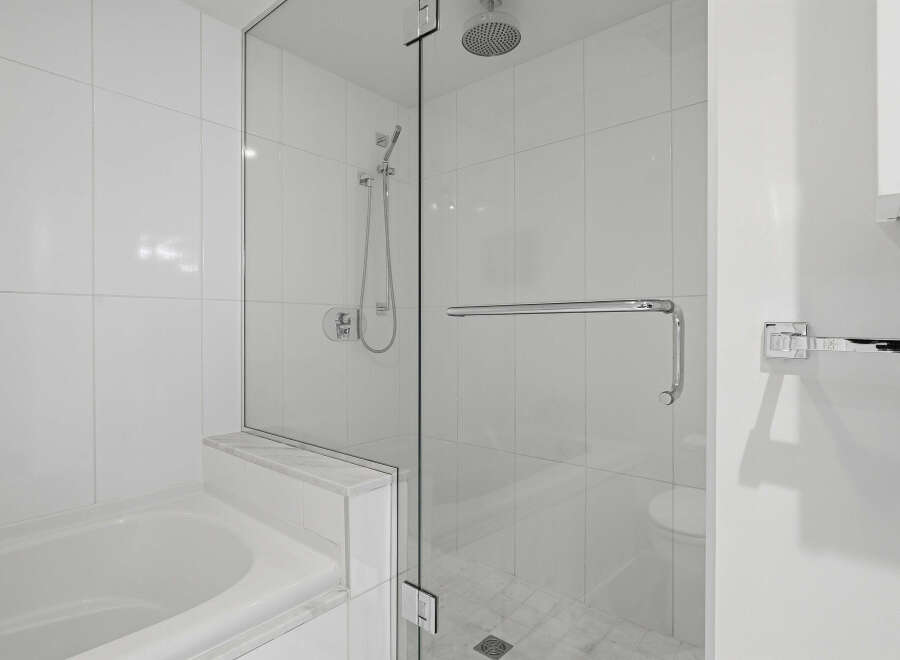 Step into luxury with this stunning bathroom featuring a sleek glass shower enclosure.