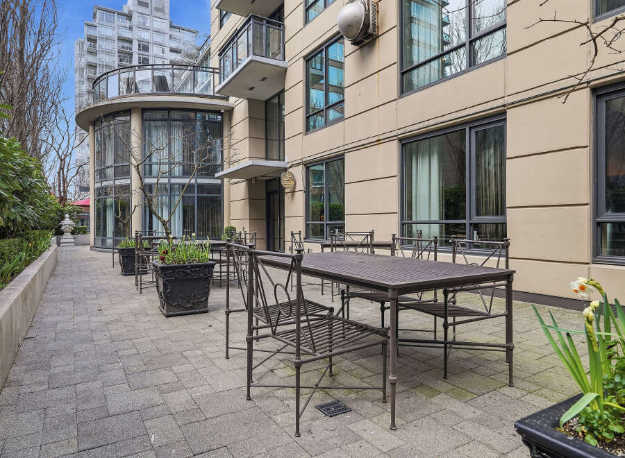 Enjoy outdoor dining at this stunning property! This image showcases a beautiful patio area with elegant metal tables and chairs, perfect for entertaining or relaxing.