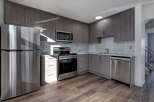 This modern kitchen boasts sleek, gray cabinetry and stainless steel appliances, creating a stylish and functional space.
