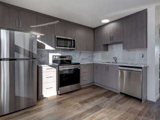 This modern kitchen boasts sleek, gray cabinetry and stainless steel appliances, creating a stylish and functional space.