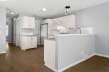 Step into this bright and airy kitchen, featuring modern white cabinetry and sleek countertops.