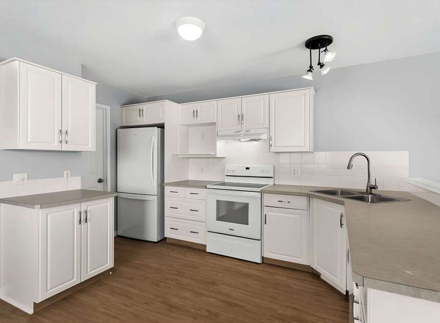 Step into this bright and airy kitchen, featuring pristine white cabinetry and sleek countertops.
