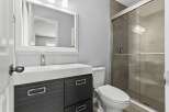 This modern bathroom features a sleek design with a spacious shower and a stylish vanity.