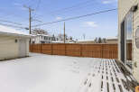 Enjoy the winter wonderland in this charming property! This home features a spacious backyard with a wooden fence, perfect for privacy and outdoor activities.