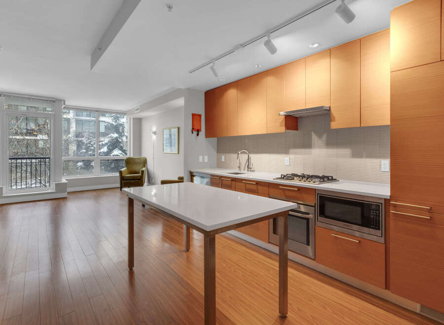 This modern kitchen boasts sleek wooden cabinetry, offering ample storage and a warm, inviting atmosphere.