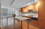 This modern kitchen boasts sleek wooden cabinetry, offering ample storage and a warm, inviting atmosphere.