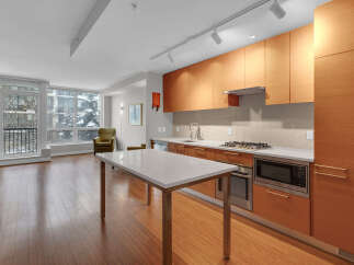 This modern kitchen boasts sleek wooden cabinetry, offering ample storage and a warm, inviting atmosphere.