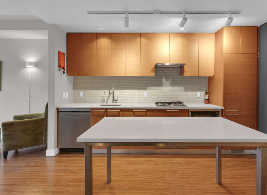 This modern kitchen boasts sleek wooden cabinetry, offering ample storage and a warm aesthetic.