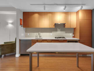 This modern kitchen boasts sleek wooden cabinetry, offering ample storage and a warm aesthetic.