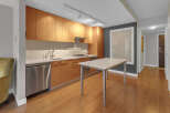 This modern kitchen boasts sleek wooden cabinetry, stainless steel appliances, and a pristine white countertop.