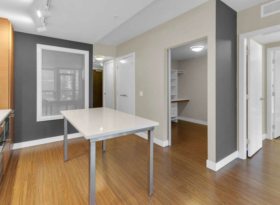 Step into modern elegance with this stunning property, featuring a sleek, white-topped table perfect for dining or work.