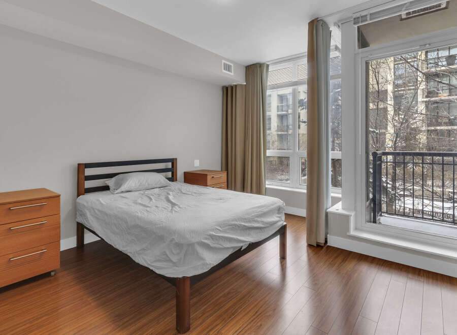 This cozy bedroom features a comfortable bed and ample natural light, perfect for relaxation.