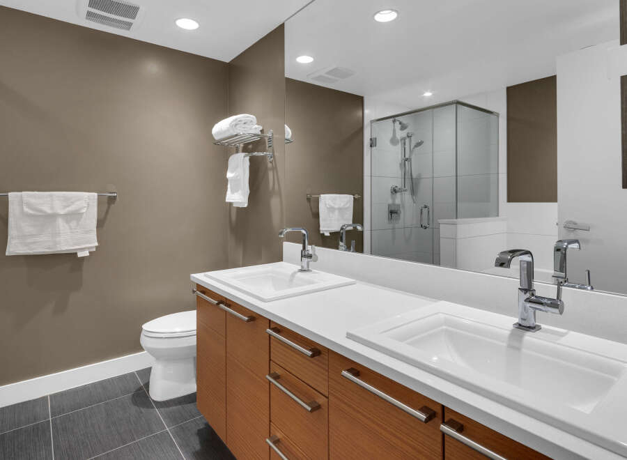 This modern bathroom boasts a sleek design with a double vanity and ample counter space, perfect for a luxurious lifestyle.