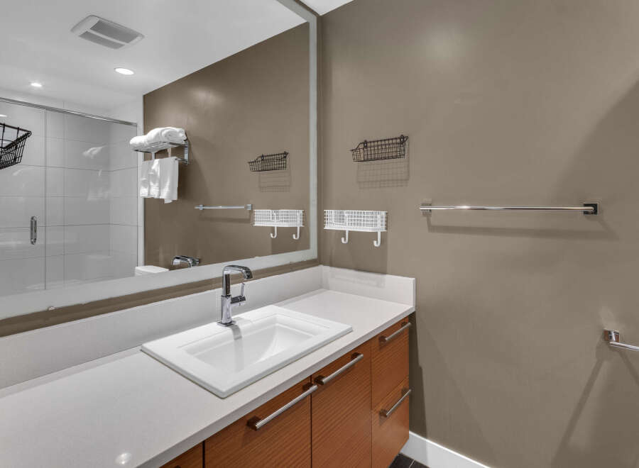 This modern bathroom features a sleek design with a white countertop and a stylish sink.