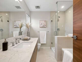 Step into a luxurious bathroom retreat, featuring a sleek marble countertop and modern fixtures.