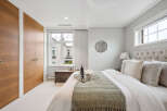 Step into luxury with this stunning bedroom, featuring a plush tufted headboard and elegant decor.
