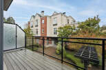 Enjoy stunning views from this beautiful property! This home features a spacious balcony with a modern glass railing, perfect for relaxing and taking in the surroundings.