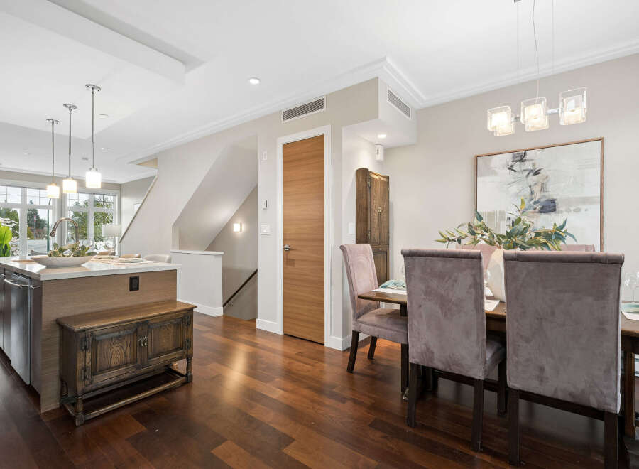Step into luxury with this stunning property, featuring a modern kitchen island and elegant dining area.