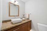 This stunning bathroom features a modern design with a sleek white sink and a beautiful granite countertop.