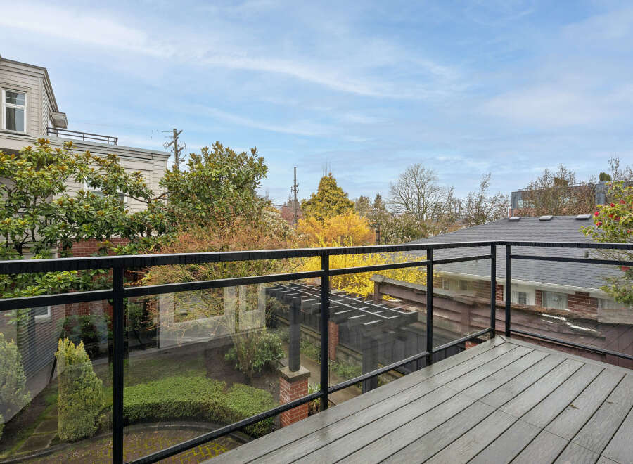 Enjoy stunning views from this beautiful property! This home features a spacious deck with a modern glass railing, perfect for relaxing and entertaining.