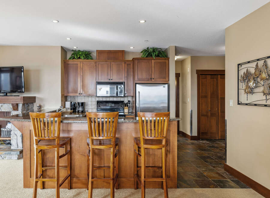 This stunning kitchen features a breakfast bar with seating for three, perfect for casual dining or entertaining.