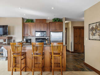 This stunning kitchen features a breakfast bar with seating for three, perfect for casual dining or entertaining.