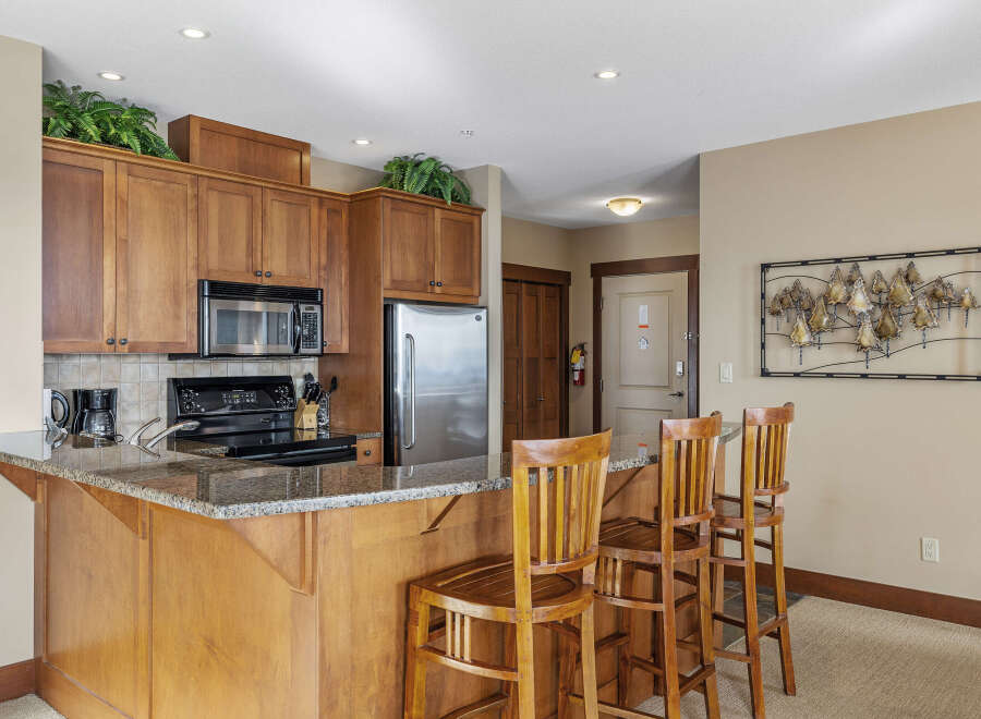 This stunning kitchen boasts beautiful wooden cabinetry, a sleek granite countertop, and modern appliances.