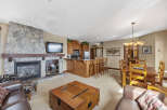 This stunning property boasts a cozy living area with a stone fireplace and a mounted TV, perfect for relaxing evenings.