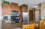 This stunning kitchen boasts beautiful wooden cabinetry, a modern stainless steel refrigerator, and a sleek microwave.