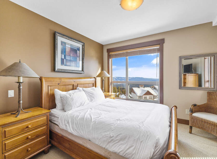 Experience the ultimate comfort in this cozy bedroom, featuring a plush bed and a stunning view.