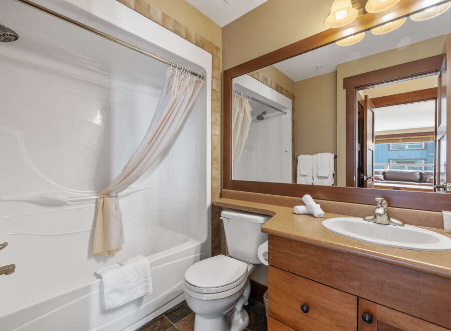 This stunning bathroom features a modern design with a sleek white bathtub and a stylish vanity.