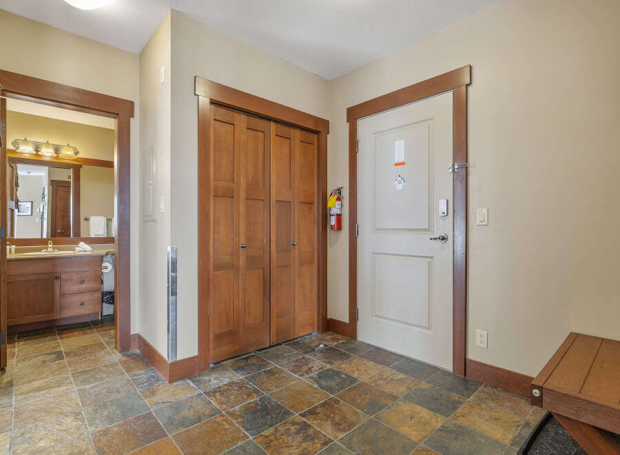 Step into this inviting entryway, featuring a warm color palette and stylish tile flooring.