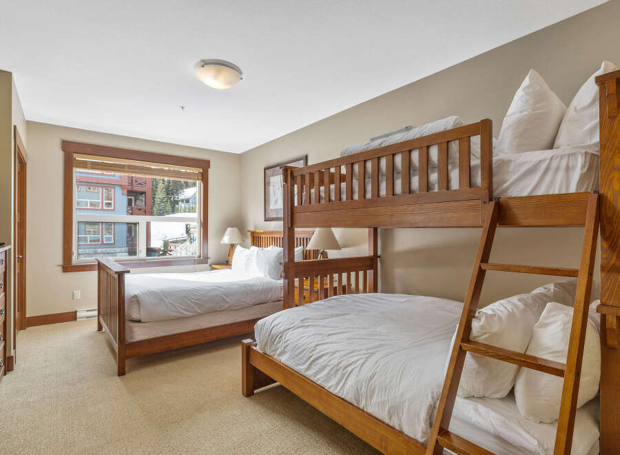 This cozy bedroom features a unique bunk bed setup, perfect for accommodating guests or family.