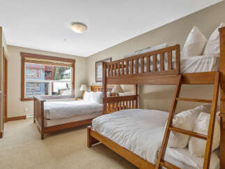 This cozy bedroom features a unique bunk bed setup, perfect for accommodating guests or family.