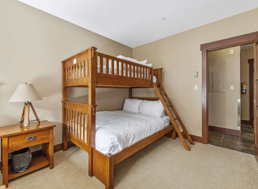This cozy bedroom features a beautiful wooden bunk bed, perfect for accommodating guests or family members.