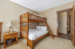 This cozy bedroom features a beautiful wooden bunk bed, perfect for accommodating guests or family members.