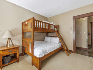 This cozy bedroom features a beautiful wooden bunk bed, perfect for accommodating guests or family members.