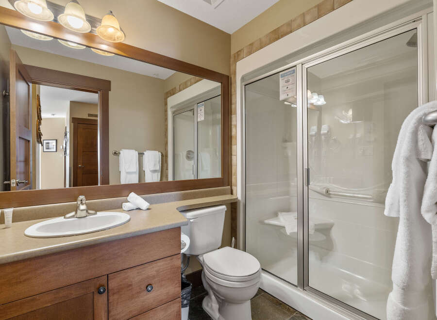 Step into a luxurious bathroom featuring a spacious walk-in shower and a sleek vanity.