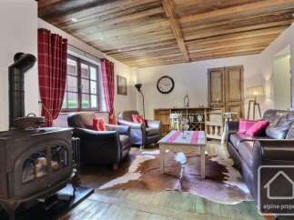 Experience rustic charm in this inviting living space, featuring a cozy fireplace and exposed wooden beams.