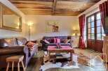 This charming property boasts a cozy living room with rustic wooden beams and a cowhide rug, creating a warm and inviting atmosphere.