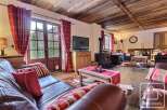 Experience the charm of this stunning property, featuring a cozy living room with a fireplace and a rustic wooden ceiling.