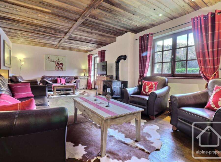 Experience rustic charm in this inviting living space, featuring a cozy fireplace and exposed wooden beams.