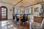 This charming dining room features a rustic wooden ceiling and a large dining table, perfect for family gatherings.