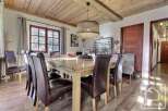 This charming dining room features a rustic wooden ceiling and a large, inviting dining table, perfect for family gatherings.