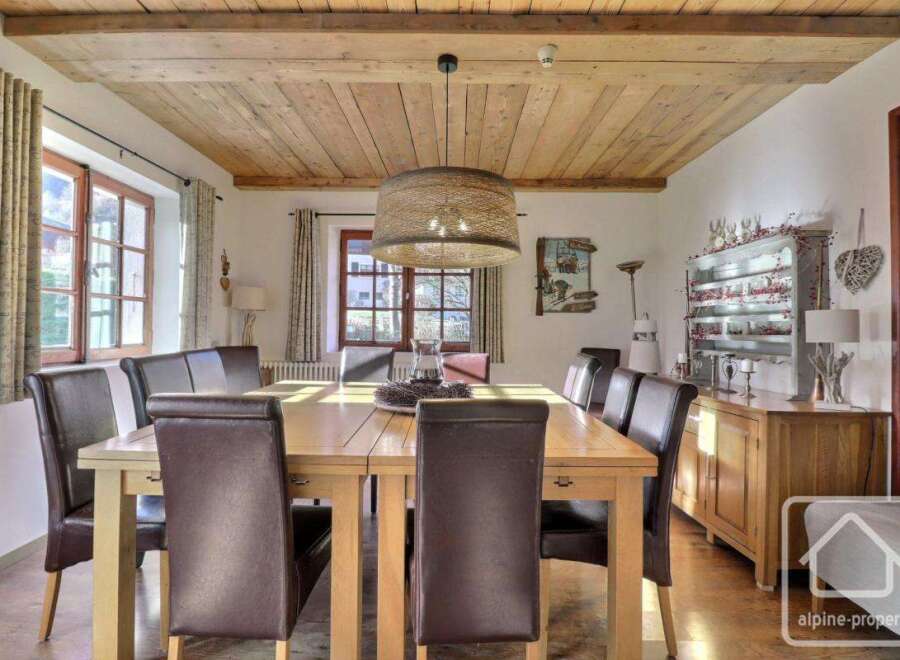 This stunning dining room showcases a rustic charm with its wooden ceiling and elegant dining table.