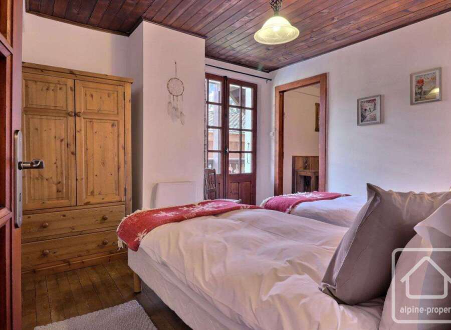 This charming bedroom features a cozy wooden ceiling and a warm, inviting atmosphere.