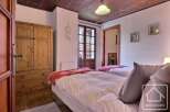 This charming bedroom features a cozy wooden ceiling and a warm, inviting atmosphere.