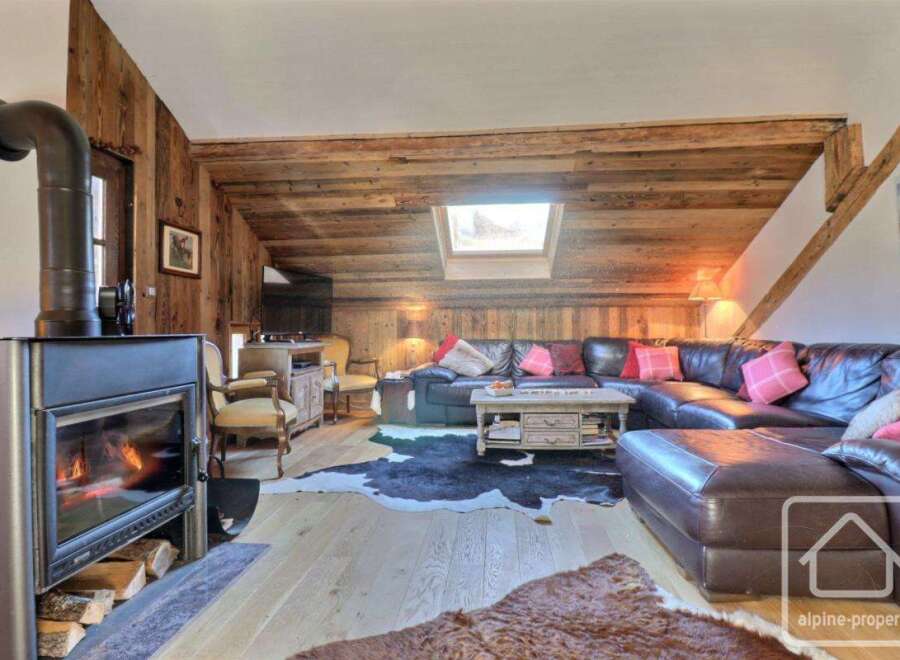 Experience the charm of this cozy living space, featuring a rustic wooden interior and a welcoming fireplace.