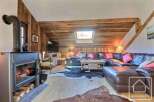 Experience the charm of this cozy living space, featuring a rustic wooden interior and a welcoming fireplace.